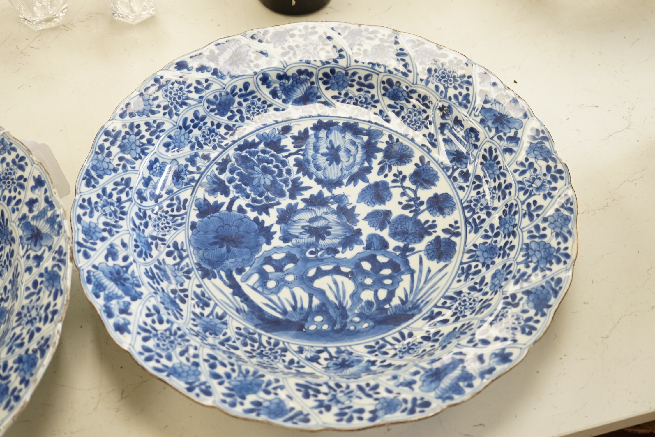 A pair of Chinese Kangxi blue and white dishes, painted with rock work and flowers, artemisia leaf marks, 37cm diameter